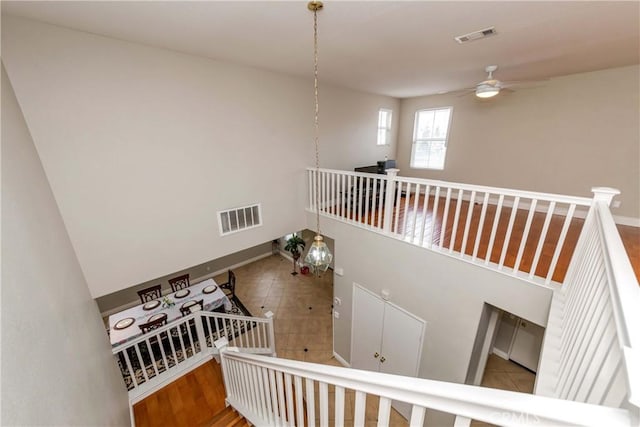 stairway featuring visible vents, a ceiling fan, and baseboards