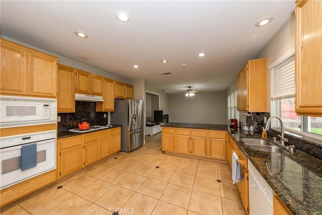 kitchen featuring tasteful backsplash, a sink, white appliances, a peninsula, and under cabinet range hood