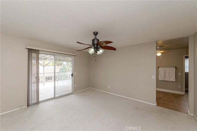carpeted spare room with baseboards and ceiling fan