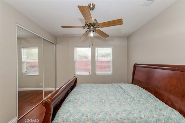 bedroom featuring wood finished floors, visible vents, baseboards, and multiple windows