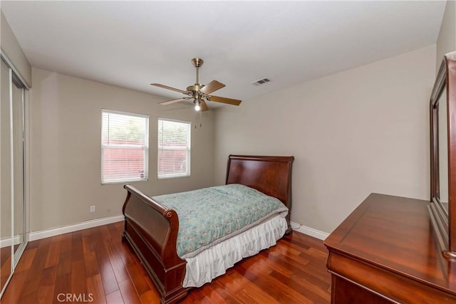 bedroom with baseboards, visible vents, a ceiling fan, and dark wood-style floors