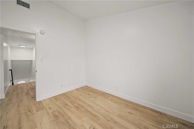 unfurnished room with baseboards and light wood-style flooring