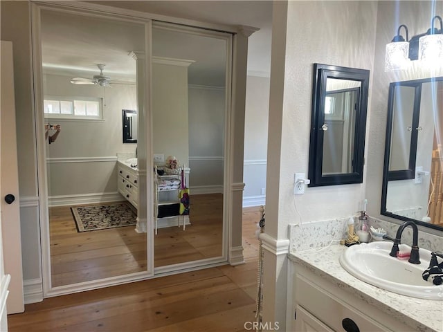 22191 Apache Dr, Lake Forest, CA 92630 - bathroom featuring crown molding, vanity, ceiling fan, and hardwood / wood-style flooring