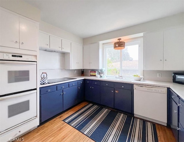 322 Calle De Arboles, Redondo Beach, CA 90277 - kitchen featuring black appliances, wood finished floors, blue cabinets, and a sink
