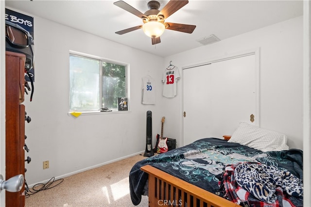 carpeted bedroom featuring baseboards, a ceiling fan, visible vents, and a closet