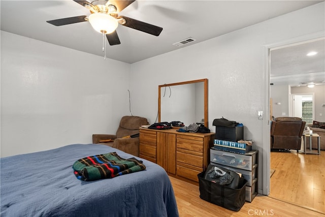 bedroom featuring a ceiling fan, light wood finished floors, and visible vents