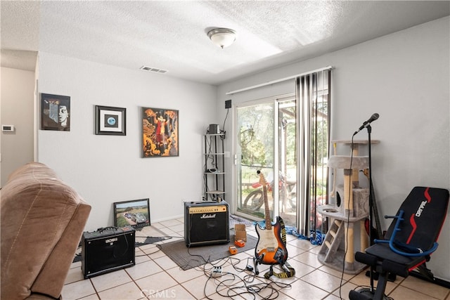 interior space with visible vents, a textured ceiling, and light tile patterned floors