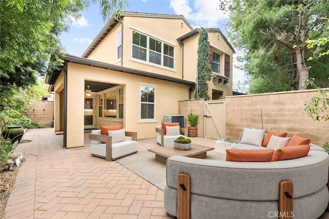 21 Deergrass, Irvine, CA 92618 - rear view of property with outdoor lounge area, a gate, a patio, and stucco siding