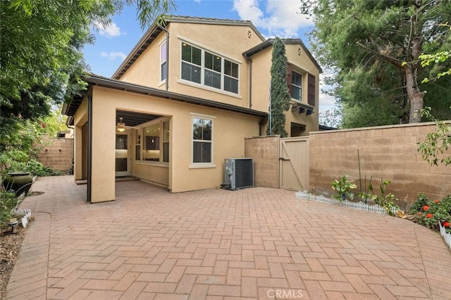21 Deergrass, Irvine, CA 92618 - back of property with a gate, a fenced backyard, a patio, and stucco siding