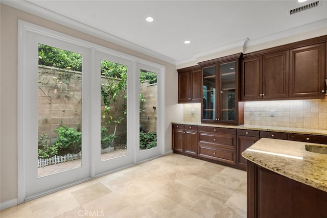 21 Deergrass, Irvine, CA 92618 - kitchen featuring tasteful backsplash, light stone countertops, dark brown cabinets, glass insert cabinets, and recessed lighting