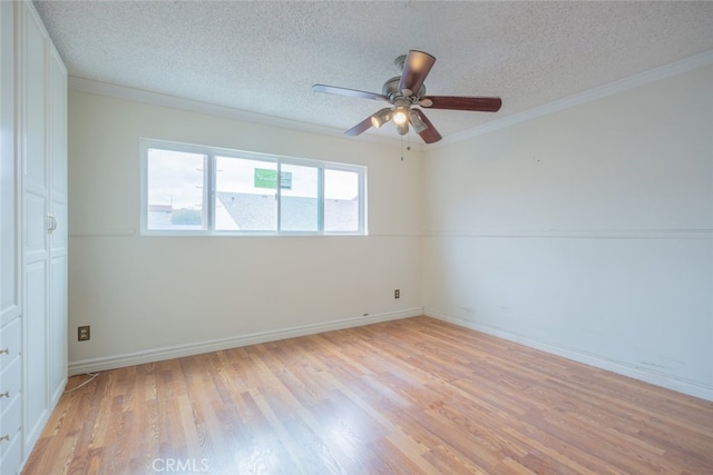 empty room featuring ceiling fan, ornamental molding, a textured ceiling, and light wood-style floors