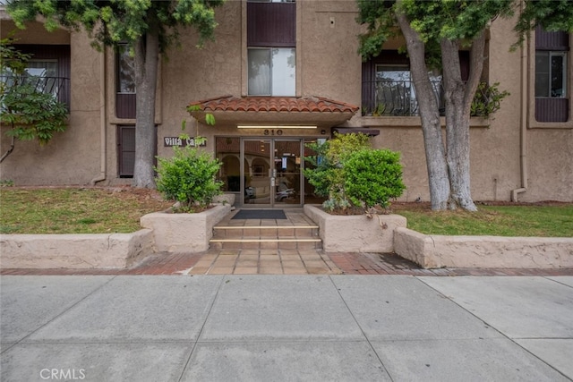 entrance to property with stucco siding