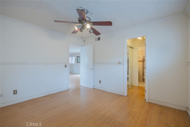 spare room with ornamental molding, visible vents, light wood finished floors, and ceiling fan