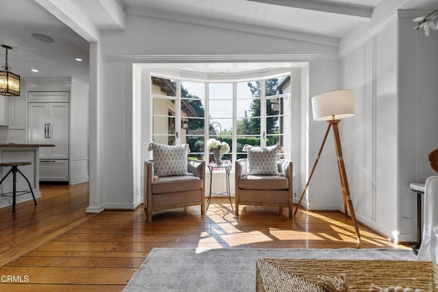 sitting room featuring baseboards, lofted ceiling with beams, an inviting chandelier, and wood-type flooring