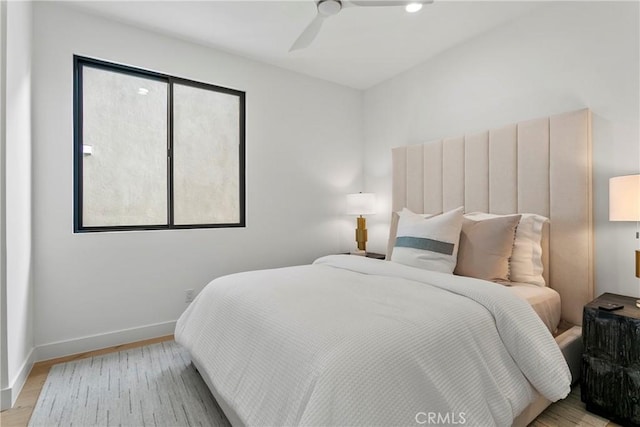 bedroom featuring light wood-type flooring, a ceiling fan, and baseboards