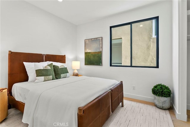 bedroom featuring baseboards and light wood-style flooring