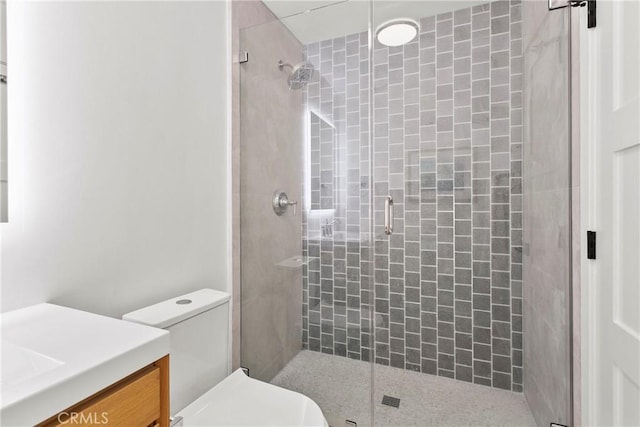 bathroom featuring vanity, toilet, and a stall shower
