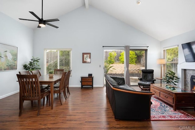 living room featuring high vaulted ceiling, ceiling fan, a tiled fireplace, and wood finished floors
