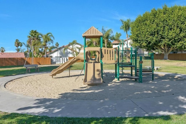 community playground featuring a lawn and fence