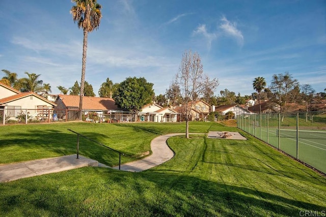 view of community featuring fence and a lawn