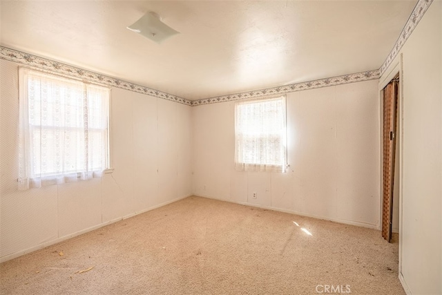 unfurnished room with baseboards and carpet