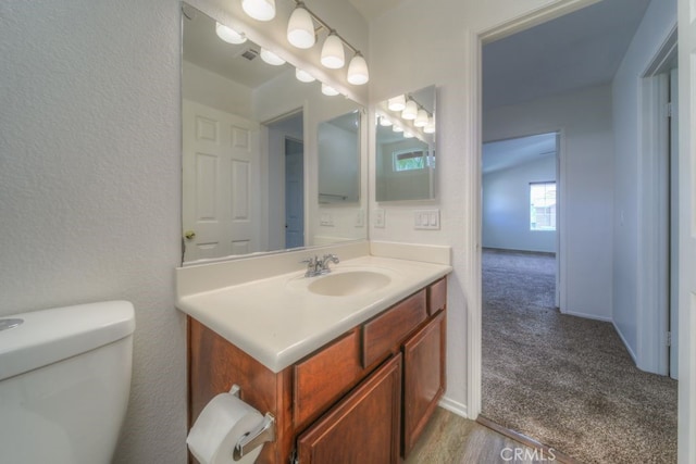bathroom with visible vents, vanity, and toilet