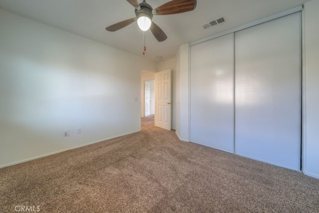 unfurnished bedroom featuring a closet, ceiling fan, baseboards, carpet flooring, and visible vents