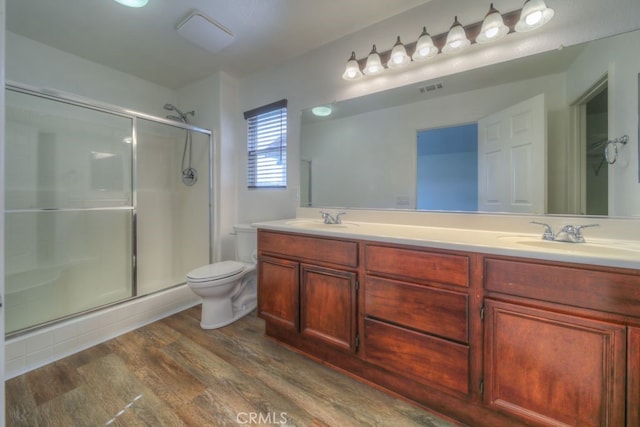 bathroom with toilet, visible vents, a sink, and a stall shower