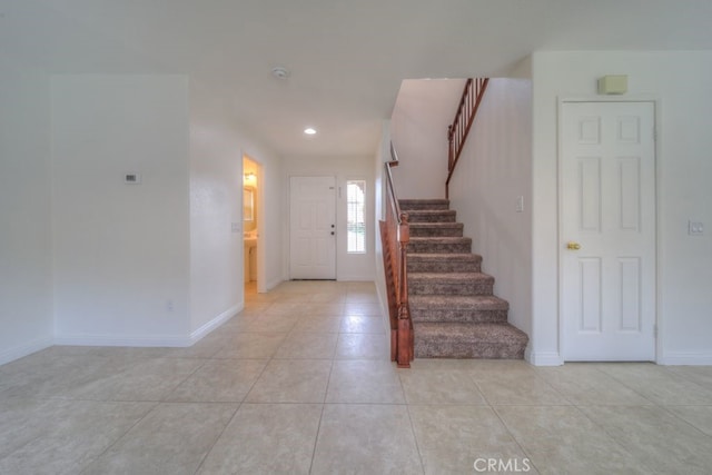 foyer entrance featuring light tile patterned flooring, stairs, baseboards, and recessed lighting