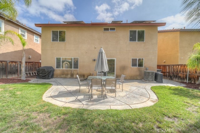 back of house featuring a lawn, central AC unit, a fenced backyard, and stucco siding