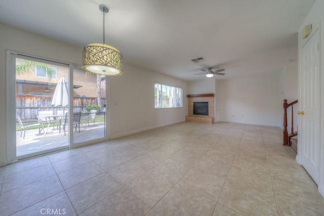 unfurnished living room with visible vents, light tile patterned floors, baseboards, a fireplace, and ceiling fan