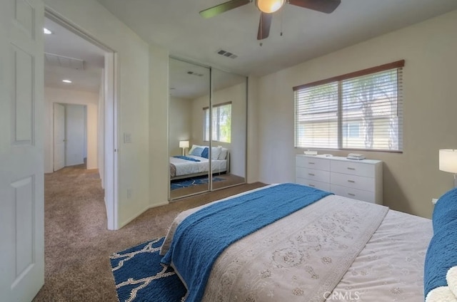 carpeted bedroom with a closet, visible vents, and a ceiling fan