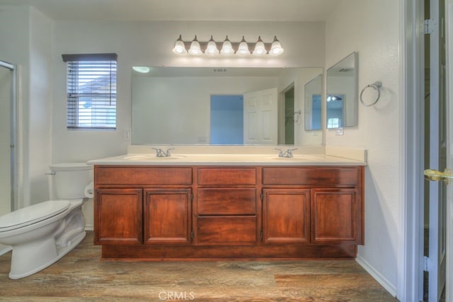 full bathroom featuring wood finished floors, a sink, and toilet