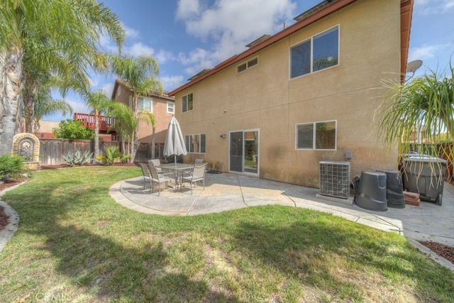 back of house with cooling unit, fence, a yard, a patio, and stucco siding