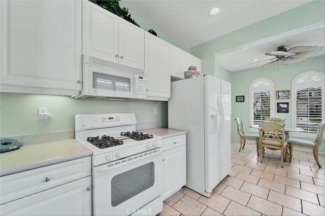 kitchen with light countertops, white cabinets, and white appliances