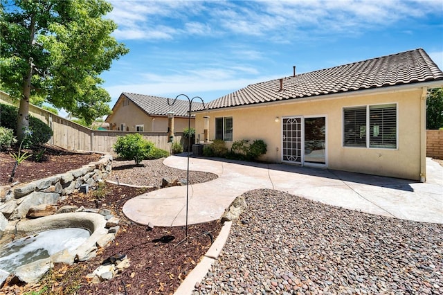 back of house featuring a patio area, stucco siding, a tile roof, and fence