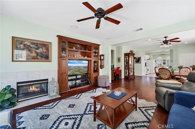 living area featuring a fireplace, a ceiling fan, recessed lighting, wood finished floors, and visible vents