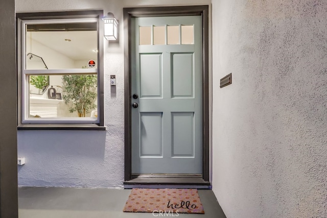 doorway to property featuring stucco siding