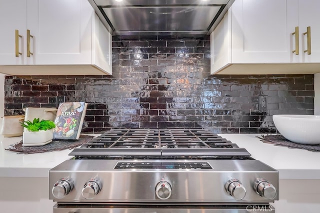 details with gas range, light countertops, backsplash, white cabinetry, and ventilation hood