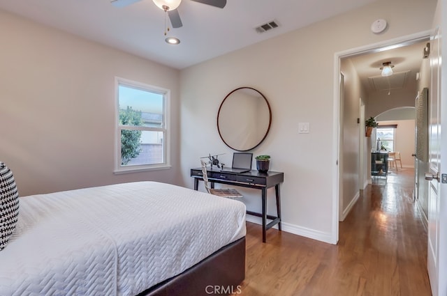 bedroom with attic access, wood finished floors, visible vents, and baseboards