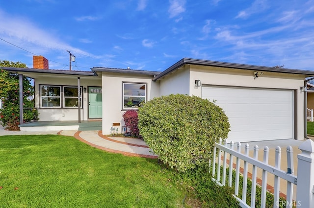 ranch-style home featuring an attached garage, a chimney, a front yard, and stucco siding