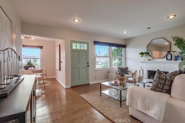 living area featuring recessed lighting, baseboards, wood finished floors, and a fireplace