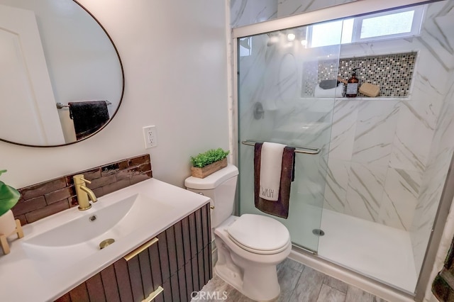 full bath with wood finished floors, a marble finish shower, decorative backsplash, vanity, and toilet