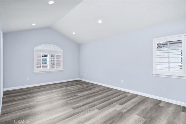 unfurnished room with baseboards, vaulted ceiling, recessed lighting, and wood finished floors