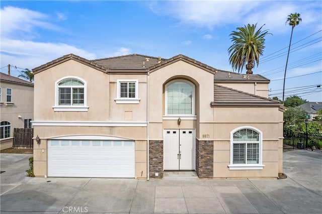 view of front of house featuring stucco siding, fence, driveway, and a garage