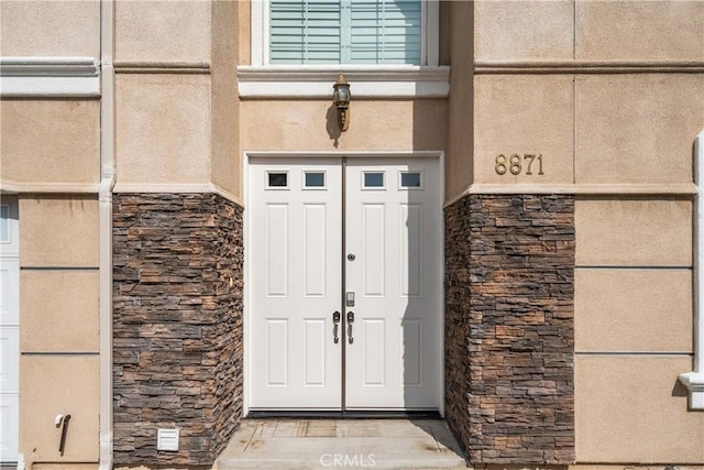 doorway to property with stone siding