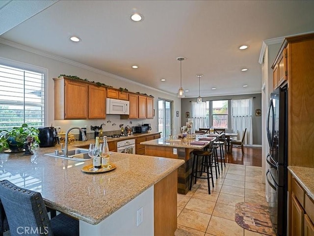 37192 Amateur Way, Beaumont, CA 92223 - kitchen featuring a center island, a kitchen breakfast bar, a sink, brown cabinetry, and white appliances