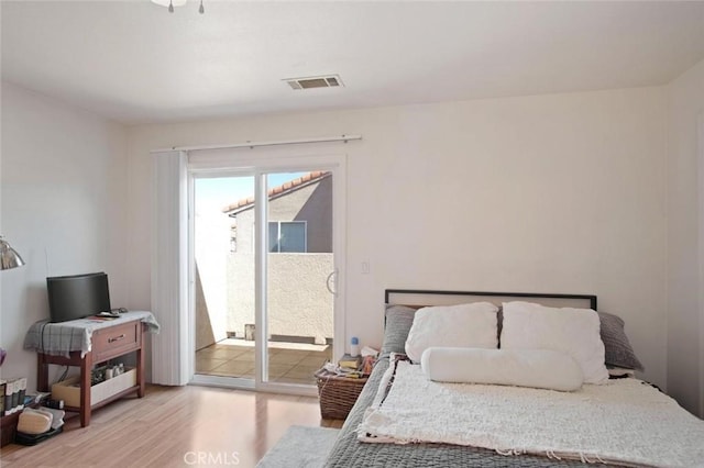 bedroom with access to outside, visible vents, and light wood-style flooring