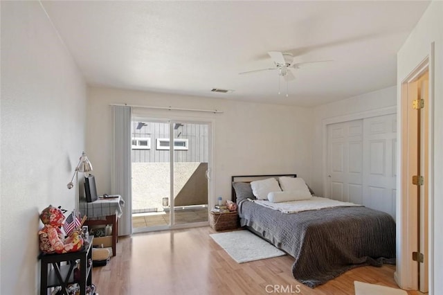 bedroom with visible vents, a ceiling fan, wood finished floors, and access to exterior