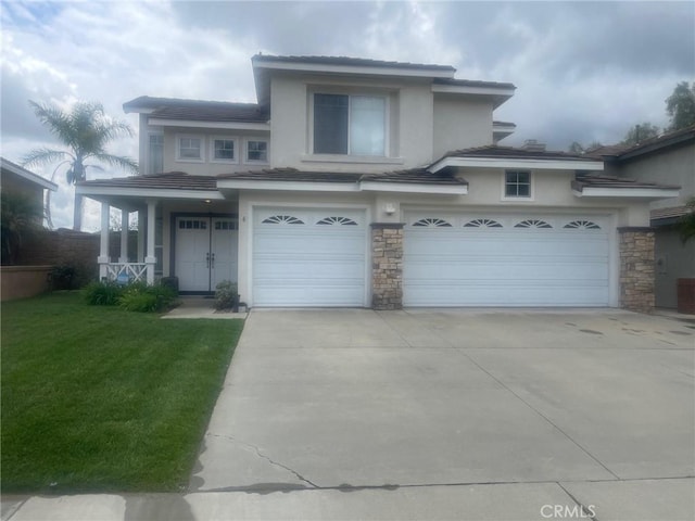 4 Chisholm Trl, Trabuco Canyon, CA 92679 - view of front of home with concrete driveway, a garage, stone siding, a front yard, and stucco siding